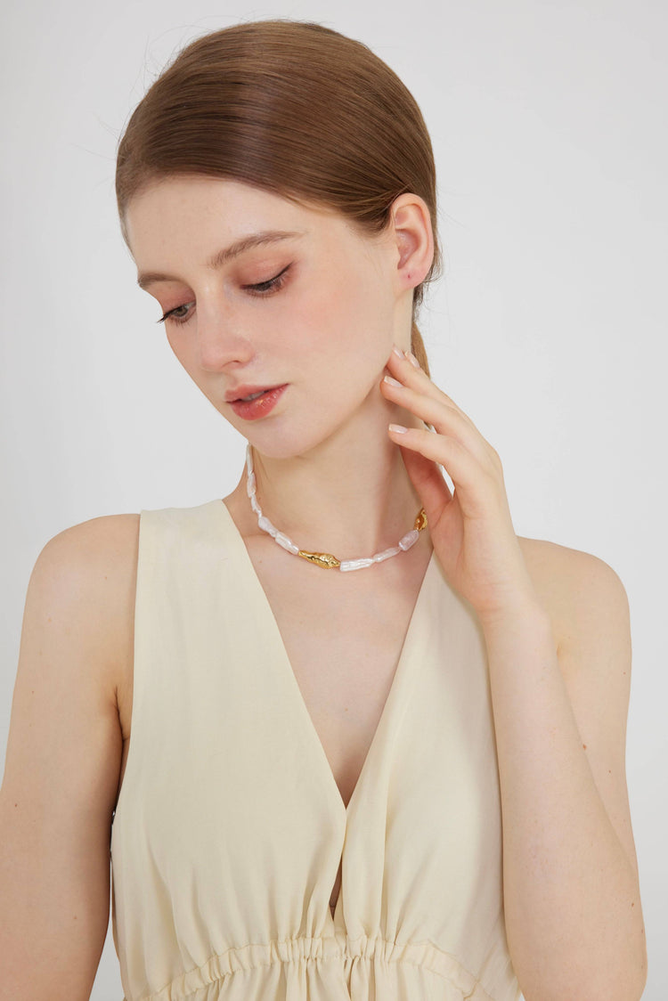 a woman wearing a necklace and a dress