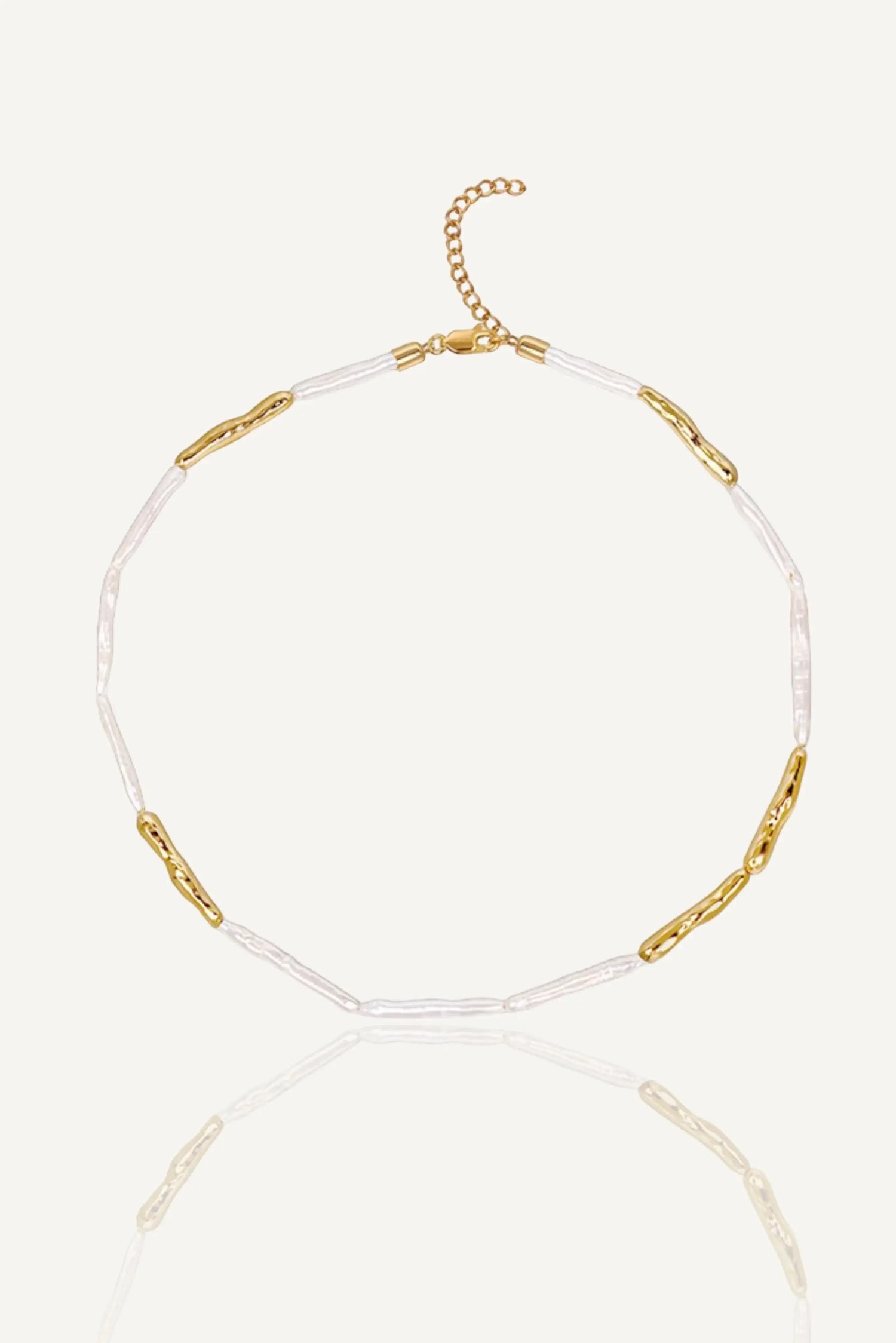 a white and gold necklace with a gold chain