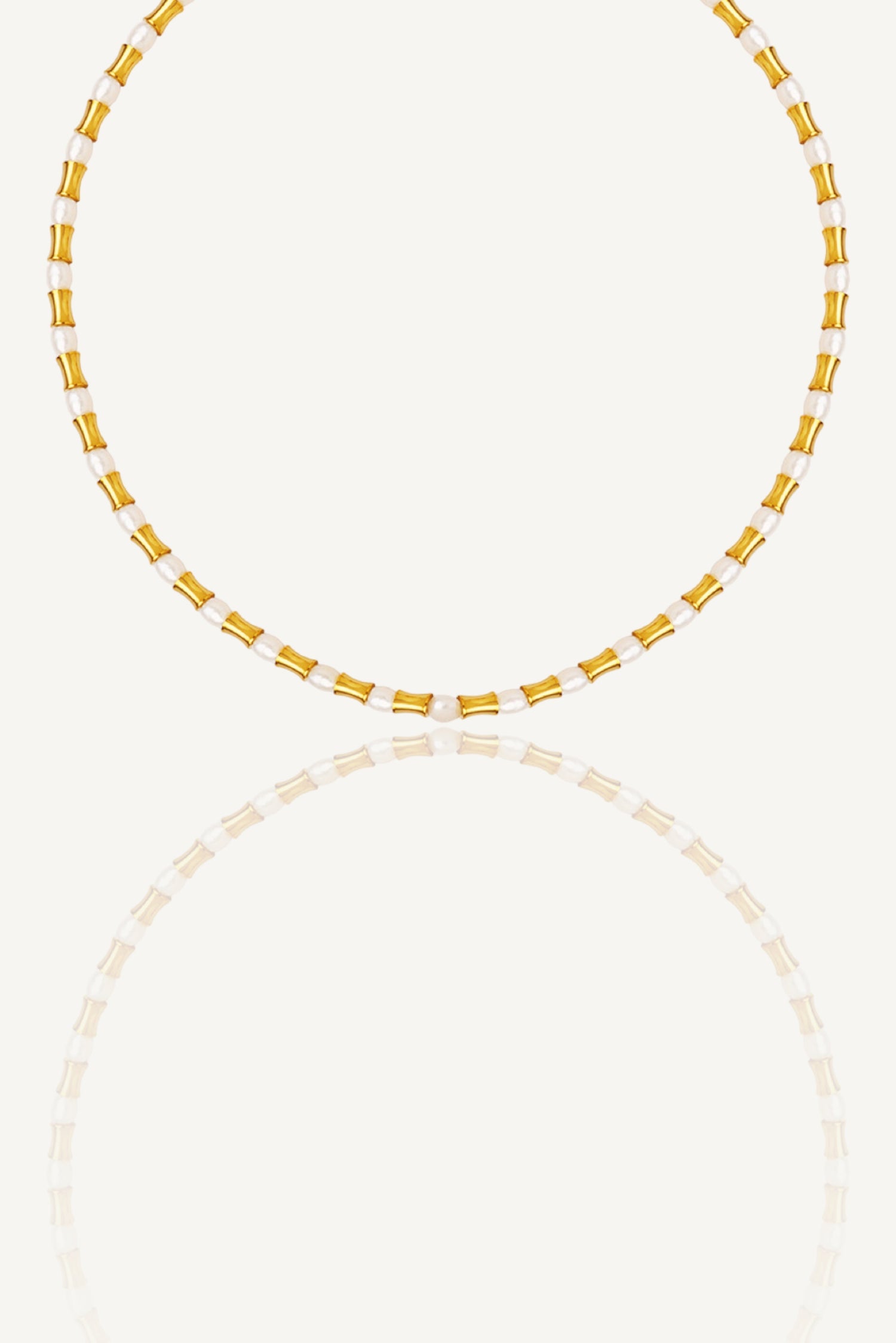 a yellow and white beaded necklace on a white background