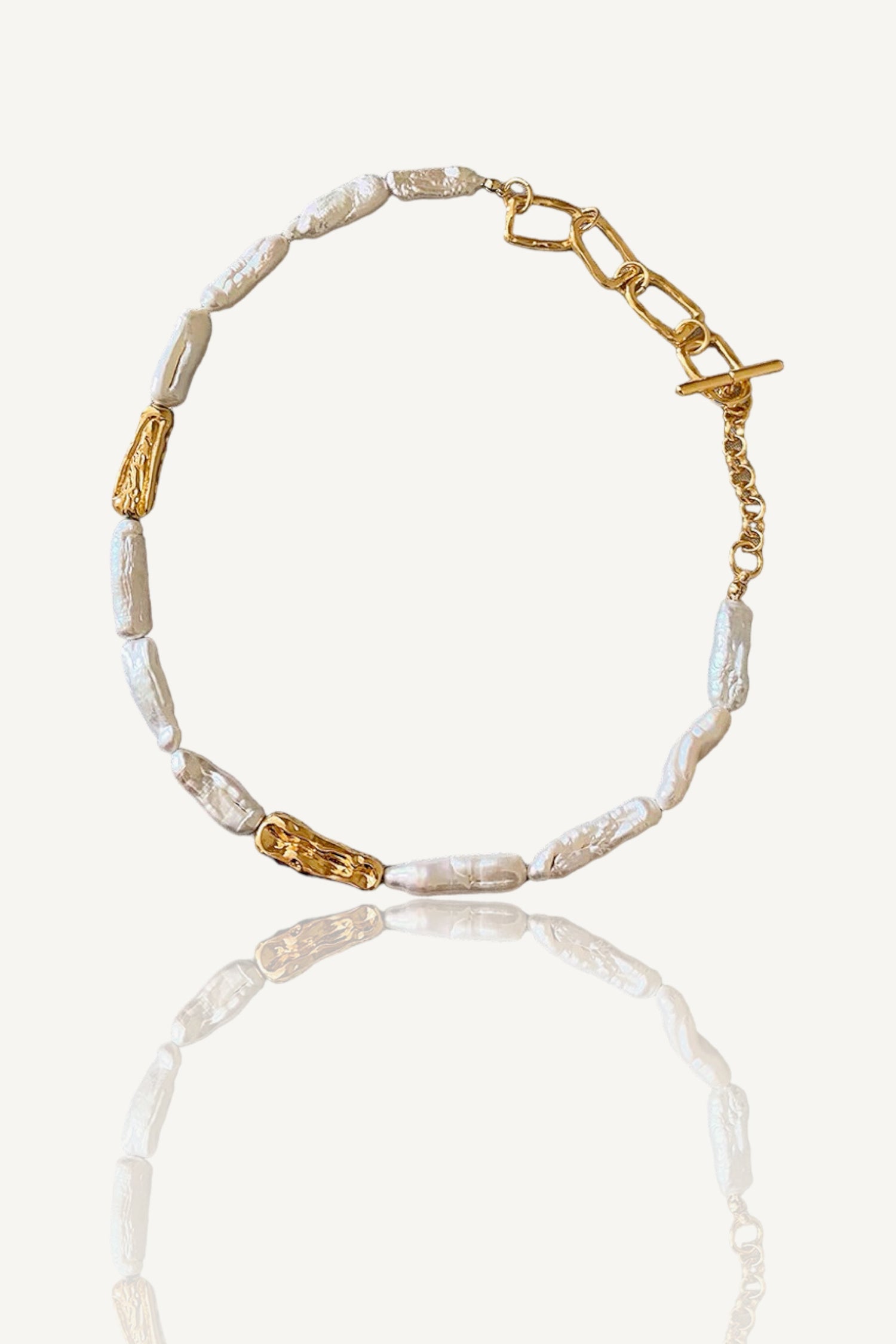 a gold and white beaded bracelet on a white background